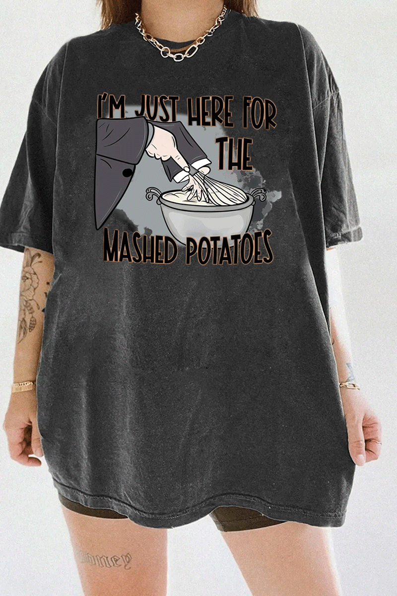 Funny dark gray t-shirt with "I'm Just Here for the Mashed Potatoes" text and a hand mixing mashed potatoes graphic, perfect for Thanksgiving or food lovers.