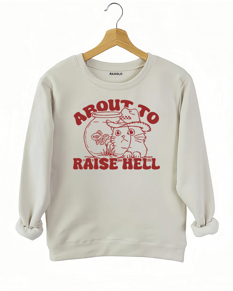 Ragglo beige women's sweatshirt with 'About to Raise Hell' text and cat in cowboy hat graphic.