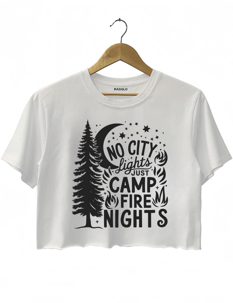 Ragglo white crop top featuring a pine tree, moon, stars, and campfire elements, with 'NO CITY LIGHTS JUST CAMP FIRE NIGHTS' text, perfect for outdoor camping streetwear for nature lovers.