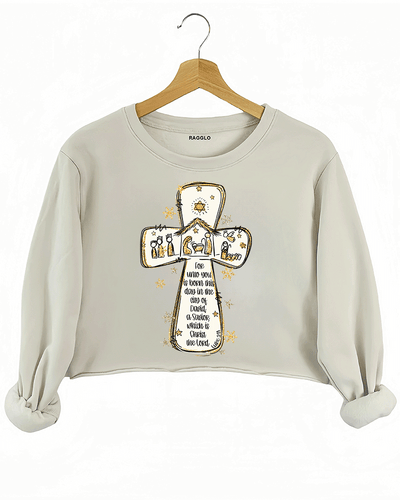 Ragglo beige crop sweatshirt featuring a cross with a nativity scene, stars, and snowflakes, with 'Unto you is born this day in the city of David, a Savior which is Christ the Lord' text, perfect for religious Christmas streetwear.