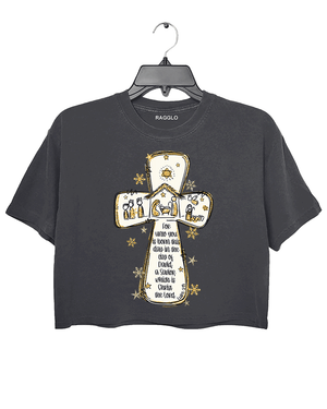 Ragglo dark gray crop top featuring a cross with a nativity scene, stars, and snowflakes, with 'Unto you is born this day in the city of David, a Savior which is Christ the Lord' text, perfect for religious Christmas streetwear.
