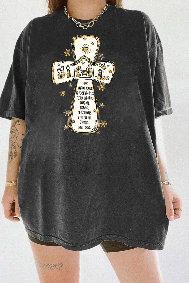 Ragglo dark gray tee featuring a cross with a nativity scene, stars, and snowflakes, with 'Unto you is born this day in the city of David, a Savior which is Christ the Lord' text, perfect for religious Christmas streetwear.