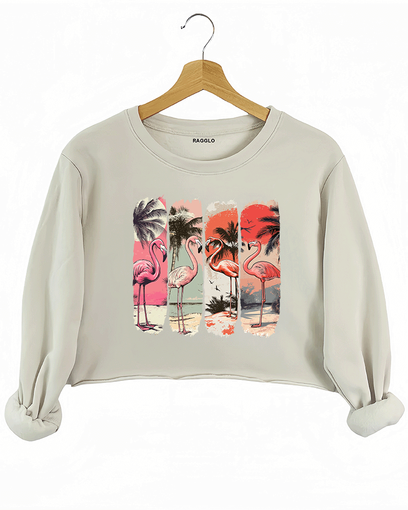 Ragglo beige crop sweatshirt featuring four pink flamingos on a beach with palm trees and a vibrant sunset, perfect for tropical-inspired casual wear.
