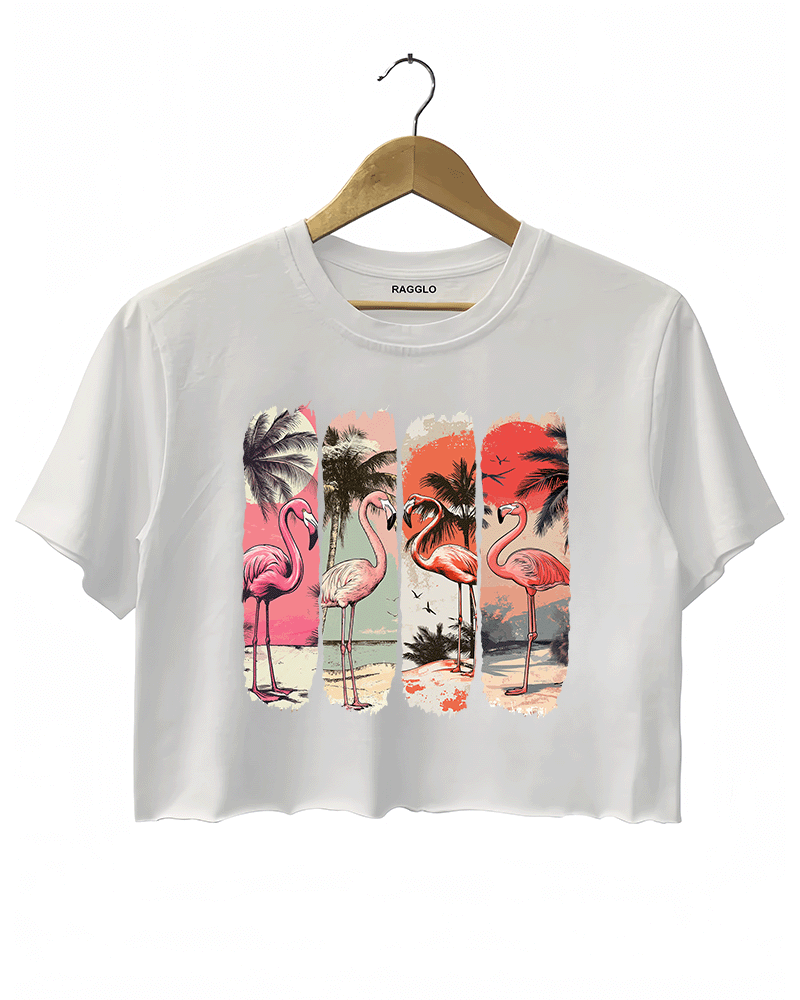 Ragglo white crop top featuring four pink flamingos on a beach with palm trees and a vibrant sunset, perfect for tropical-inspired casual wear.