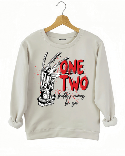 Ragglo beige sweatshirt with Freddy Krueger claw graphic and "One Two Freddy's Coming For You" text, inspired by A Nightmare on Elm Street horror theme.