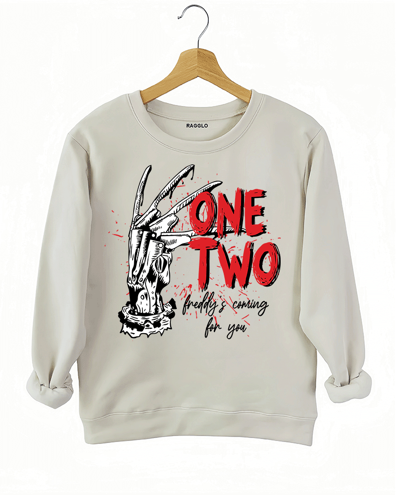 Ragglo beige sweatshirt with Freddy Krueger claw graphic and "One Two Freddy's Coming For You" text, inspired by A Nightmare on Elm Street horror theme.