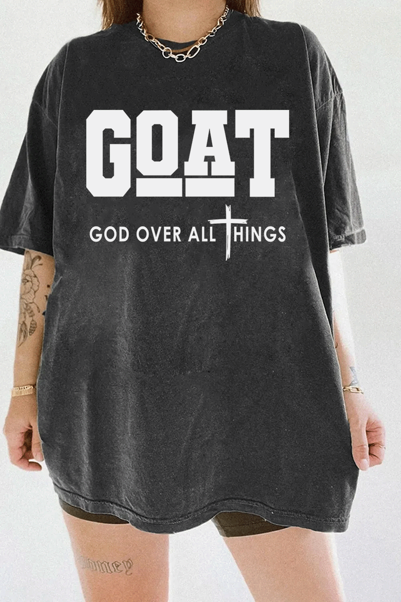 Ragglo dark gray T-shirt with "GOAT God Over All Things" text and cross symbol in white, featuring a Christian faith-inspired design.