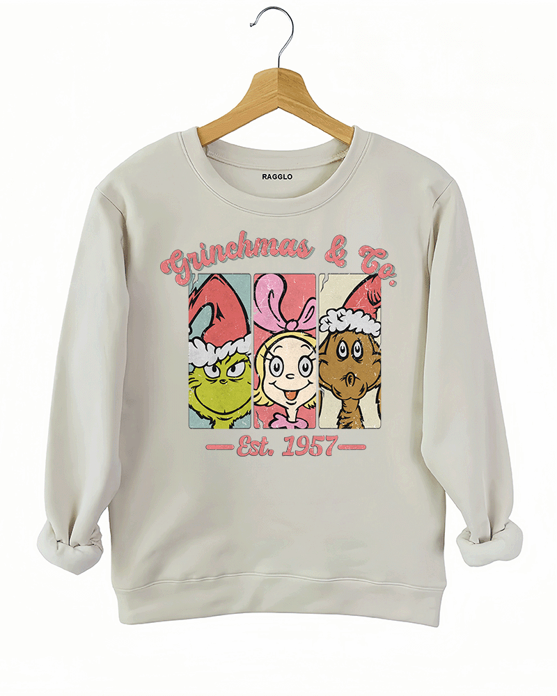 Ragglo beige sweatshirt featuring The Grinch, Cindy Lou Who, and Max in Santa hats with 'GRINCHMAS & GO' text and 'EST. 1957', perfect for festive holiday streetwear and Grinch fans.