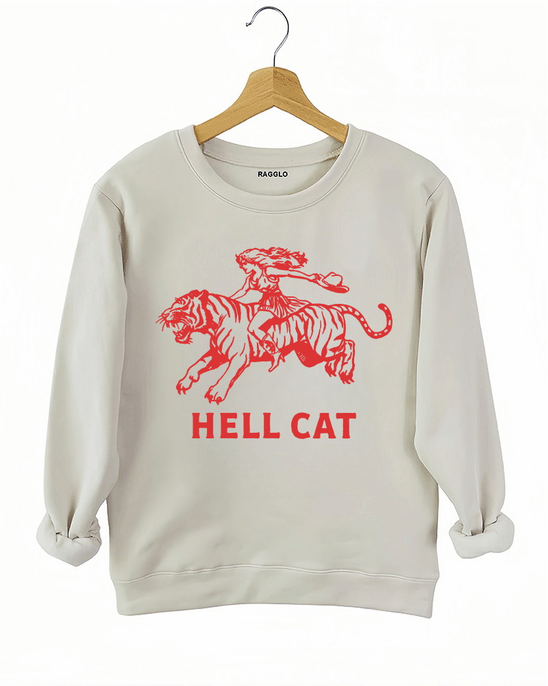 Ragglo beige sweatshirt featuring 'HELL CAT' text in red with a graphic of a woman riding a tiger, perfect for bold streetwear and fierce, rebellious vibes.