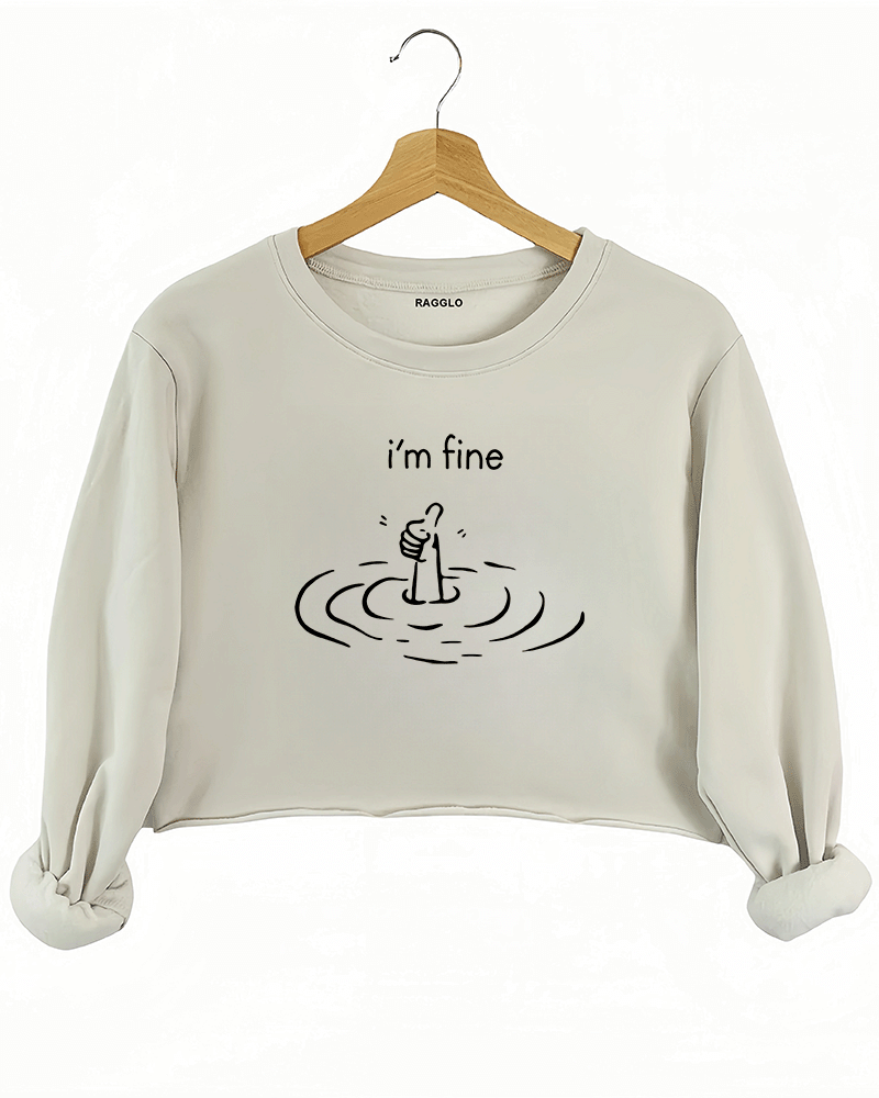 Ragglo beige crop sweatshirt featuring 'i’m fine' text with a sarcastic drowning hand graphic, perfect for mental health awareness and humorous streetwear.