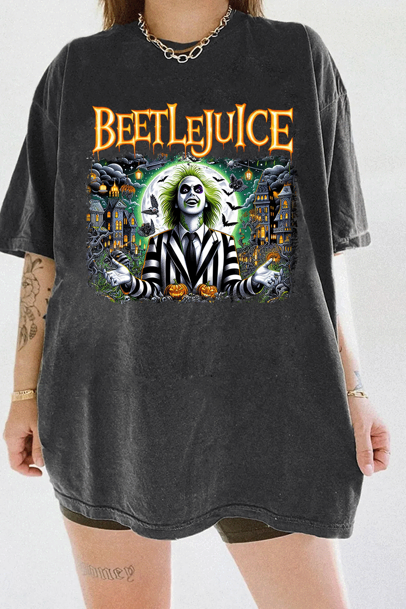 Ragglo dark gray tee featuring Beetlejuice in a black-and-white striped suit, with a haunted house, bats, and pumpkins in the background, with 'BEETLEJUICE' text, perfect for Halloween streetwear and movie fans.