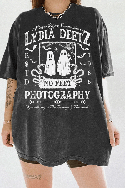 Ragglo dark gray T-shirt with "Lydia Deetz Photography No Feet" graphic featuring two ghosts, inspired by Beetlejuice with a gothic and supernatural theme.