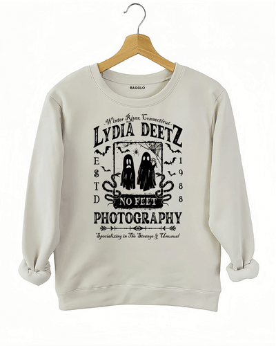 Ragglo beige sweatshirt with "Lydia Deetz Photography No Feet" graphic featuring two ghosts, inspired by Beetlejuice with a gothic and supernatural theme.