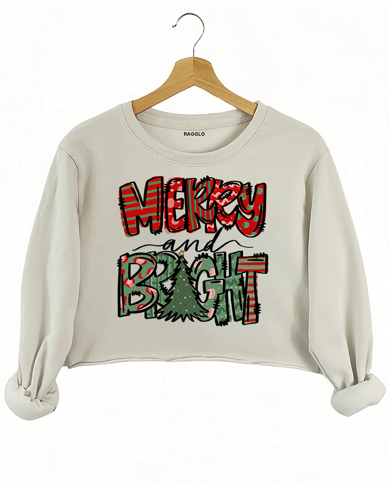 Ragglo beige crop sweatshirt featuring 'MERRY AND BRIGHT' text with red and green festive lettering and a Christmas tree design, perfect for holiday streetwear and festive celebrations.