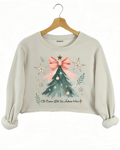 Ragglo beige crop sweatshirt featuring a Christmas tree with a pink bow, stars, snowflakes, and branches, with 'Oh Come Let Us Adore Him' text, perfect for religious Christmas streetwear.