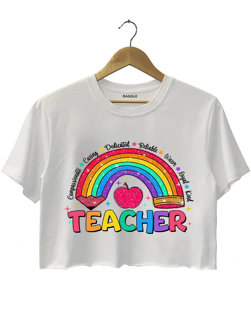 Ragglo white crop top featuring a glittery rainbow with a heart and pencil, surrounded by words like 'Compassionate' and 'Caring', with 'TEACHER' text, perfect for educators and teacher appreciation streetwear.