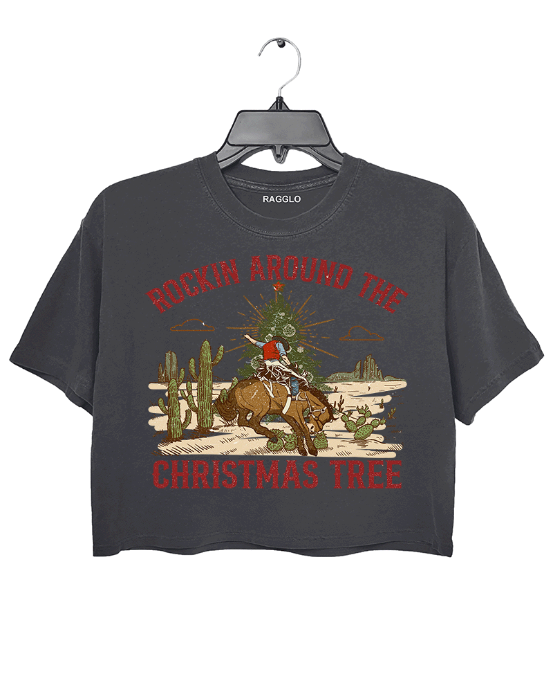 Ragglo dark gray crop top featuring a cowboy riding a horse with a Christmas tree in a desert scene with cacti, with 'ROCKIN AROUND THE CHRISTMAS TREE' text, perfect for festive western-style streetwear.