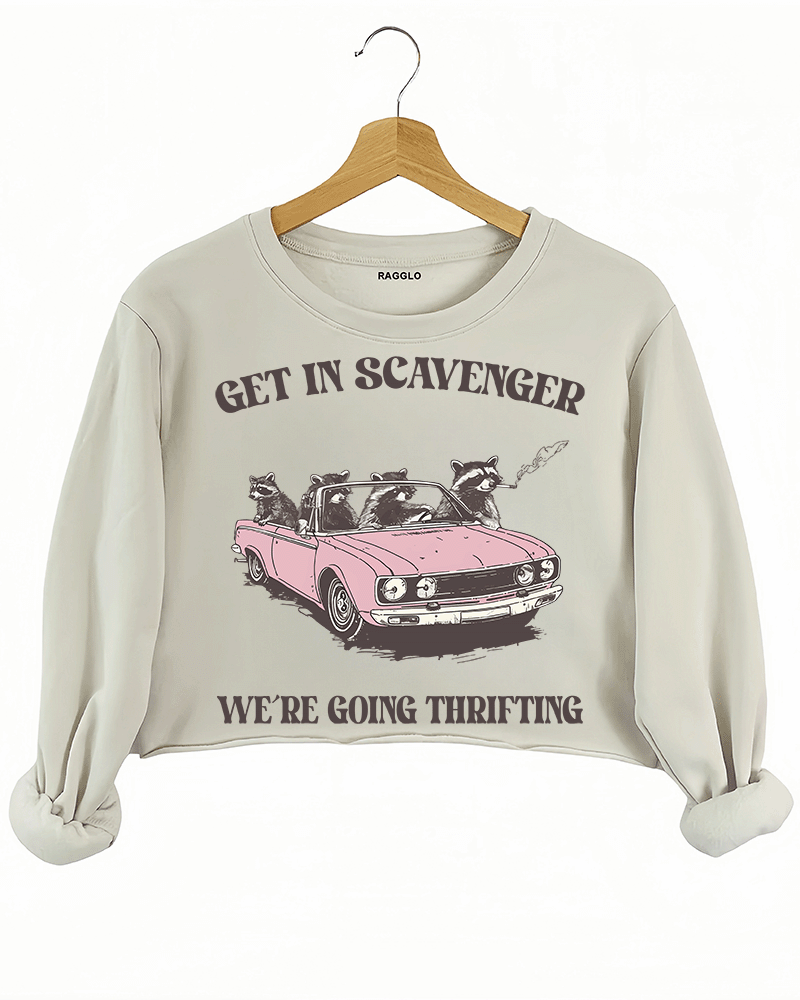Ragglo beige crop sweatshirt featuring raccoons in a pink convertible car, with 'GET IN SCAVENGER WE’RE GOING THRIFTING' text, perfect for funny retro streetwear for thrifting enthusiasts.