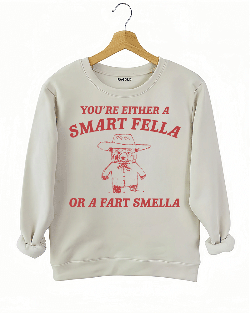 Ragglo beige sweatshirt featuring 'YOU’RE EITHER A SMART FELLA OR A FART SMELLA' text with a bear in a cowboy hat, perfect for casual streetwear and humorous everyday wear.