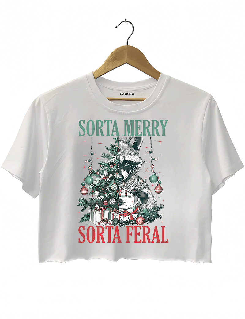 Ragglo white crop top featuring a raccoon with a decorated Christmas tree, gifts, and 'SORTA MERRY SORTA FERAL' text, perfect for funny Christmas streetwear.