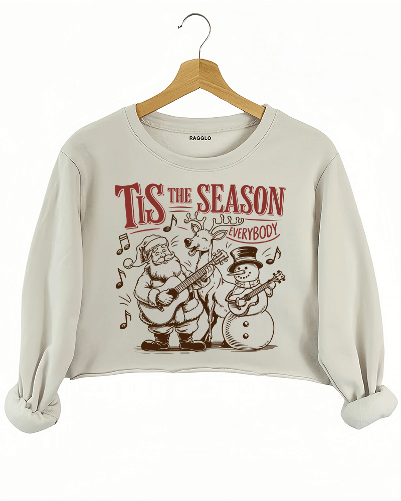 Ragglo beige crop sweatshirt featuring Santa, a reindeer, and a snowman playing guitars with musical notes and 'TIS THE SEASON EVERYBODY' text, perfect for festive Christmas streetwear with a musical vibe.