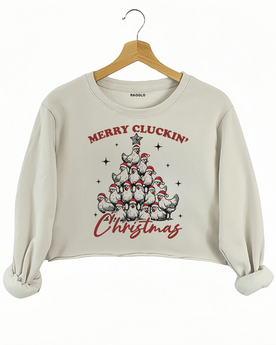 Humorous Christmas chicken design with a tree of chickens and the text 'Merry Cluckin' Christmas' on a beige crop sweatshirt, available on Ragglo.