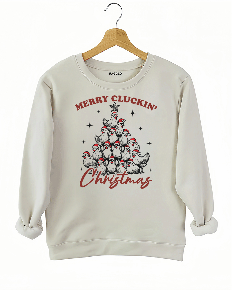 Funny holiday graphic with chickens stacked as a Christmas tree and the text 'Merry Cluckin' Christmas' on a beige sweatshirt, available on Ragglo.