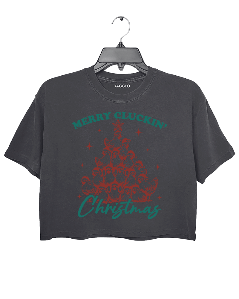 Merry Cluckin' Christmas graphic featuring chickens stacked like a Christmas tree with festive hats on a dark gray crop top, available on Ragglo.