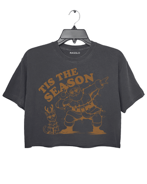 Tis The Season graphic featuring Santa dabbing with heart-shaped sunglasses and wrapped in Christmas lights, along with a festive cat also in lights, printed on a dark gray crop top - available on Ragglo.