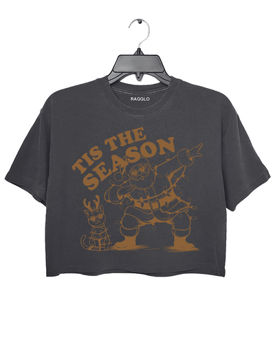 Tis The Season graphic featuring Santa dabbing with heart-shaped sunglasses and wrapped in Christmas lights, along with a festive cat also in lights, printed on a dark gray crop top - available on Ragglo.
