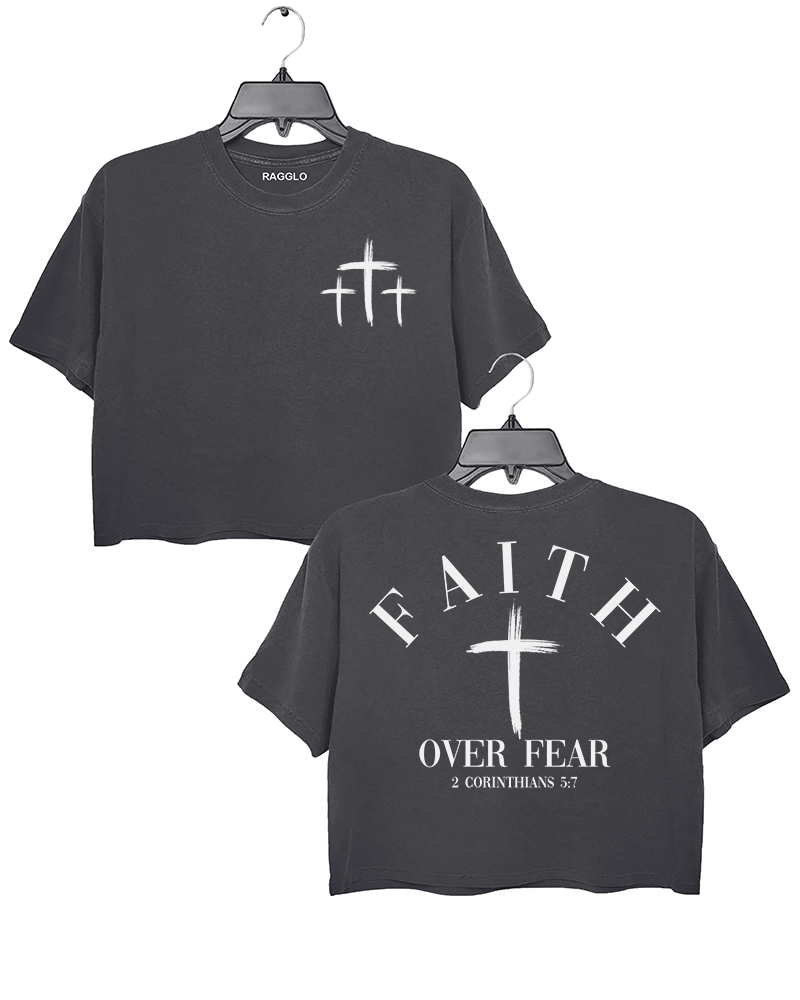 Dark gray Ragglo crop top with three small white cross designs on the front and "Faith Over Fear" with "2 Corinthians 5:7" text plus a prominent white cross design on the back.