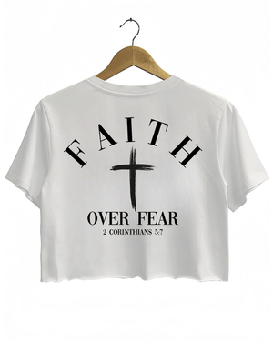 White Ragglo crop top with "Faith Over Fear" and "2 Corinthians 5:7" text on the back, featuring a prominent white cross design.
