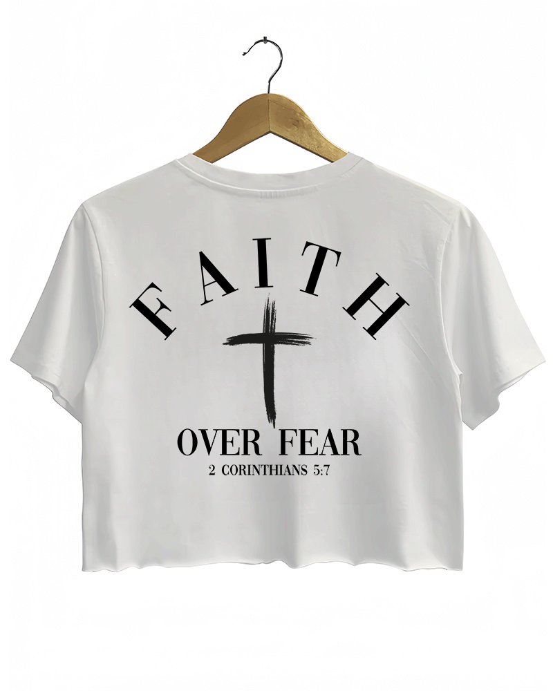 White Ragglo crop top with "Faith Over Fear" and "2 Corinthians 5:7" text on the back, featuring a prominent white cross design.