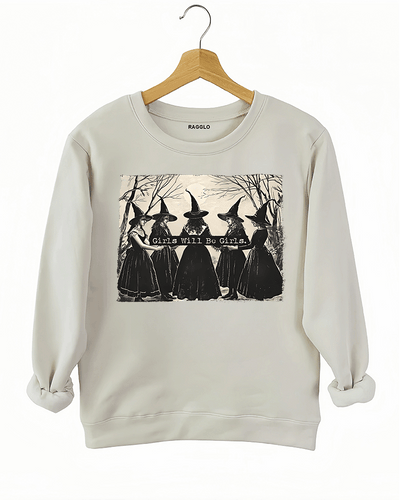 Beige sweatshirt featuring five witches in gothic-style gowns and hats, standing in a mysterious forest, with the phrase 'Girls Will Be Girls,' available on Ragglo.