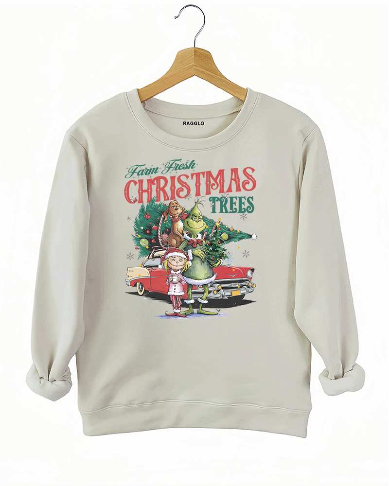 Beige sweatshirt featuring a Grinch Christmas scene with festive decorations, including Grinch, Cindy Lou, and Max with a holiday-themed vintage car.