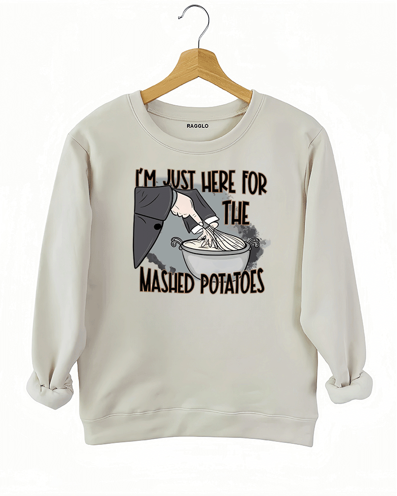Funny beige sweatshirt with "I'm Just Here for the Mashed Potatoes" text and a hand mixing mashed potatoes graphic, perfect for Thanksgiving or food lovers.

