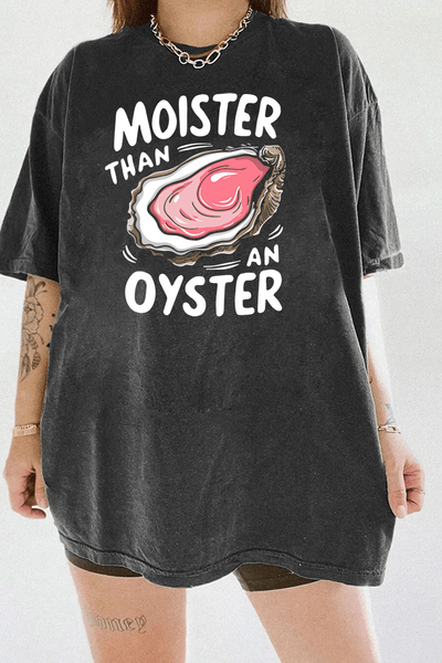 Deep gray T-shirt with 'Moister than an Oyster' graphic design, featuring a juicy oyster illustration and playful bold text, creating a cheeky, humorous vibe.