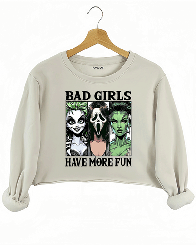 Ragglo beige cropped sweatshirt showcasing a graphic of Lydia Deetz from Beetlejuice, Ghostface from Scream, and Frankenstein's Bride, a cozy choice for horror lovers.