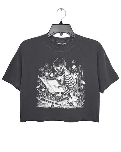 Ragglo dark gray crop top with skeleton reading book graphic surrounded by flowers and butterflies.

