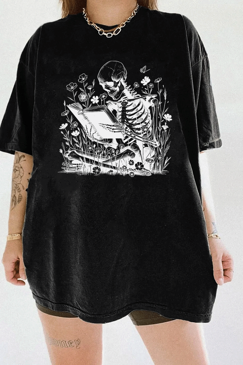 Ragglo black t-shirt with skeleton reading book graphic surrounded by flowers and butterflies.

