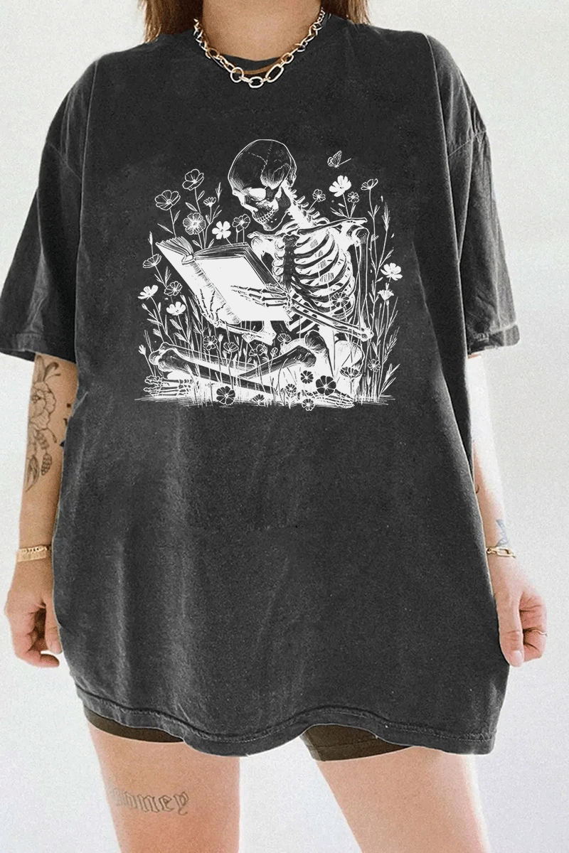 Ragglo dark gray t-shirt with skeleton reading book graphic surrounded by flowers and butterflies.

