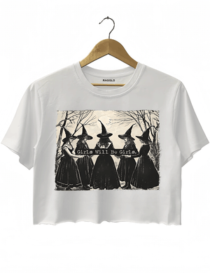 Ragglo white women's crop top featuring five witches in black hats holding a sign with the text 'Girls Will Be Girls' in a spooky forest background.