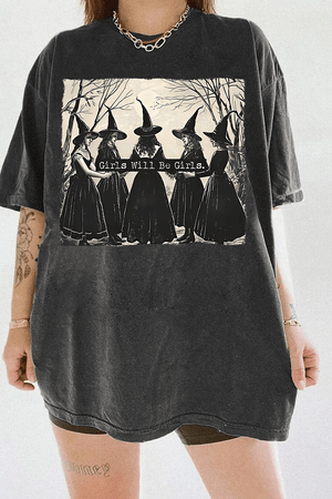 Ragglo dark gray women's T-shirt featuring five witches in black hats holding a sign with the text 'Girls Will Be Girls' in a spooky forest background.