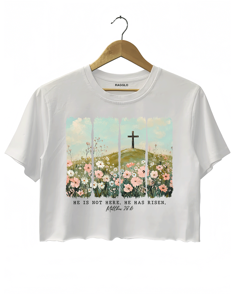Ragglo white women's crop top with 'He Is Not Here, He Has Risen' text and cross on hill with wildflowers graphic.

