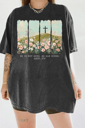 Ragglo dark gray women's t-shirt with 'He Is Not Here, He Has Risen' text and cross on hill with wildflowers graphic.