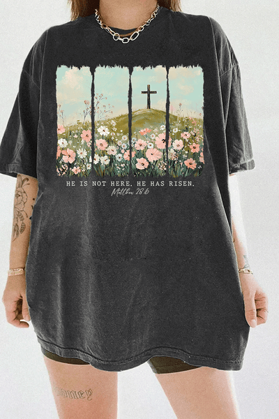 Ragglo dark gray women's t-shirt with 'He Is Not Here, He Has Risen' text and cross on hill with wildflowers graphic.