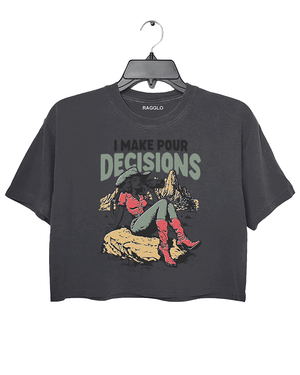 Dark Gray Ragglo women's crop t-shirt with 'I Make Pour Decisions' text and an illustration of a cowgirl sitting on a rock in a desert landscape.

