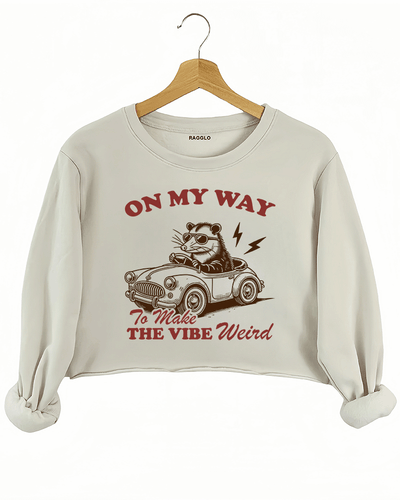 Ragglo beige women's crop sweatshirt with skeleton reading book graphic surrounded by flowers and butterflies.

