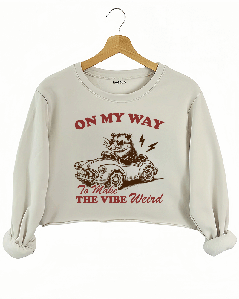 Ragglo beige women's crop sweatshirt with skeleton reading book graphic surrounded by flowers and butterflies.

