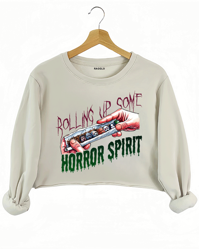 Ragglo beige crop sweatshirt featuring a hand rolling a cigarette with horror movie characters' faces, with 'ROLLING UP SOME HORROR SPIRIT' text, perfect for Halloween streetwear for horror movie fans.

